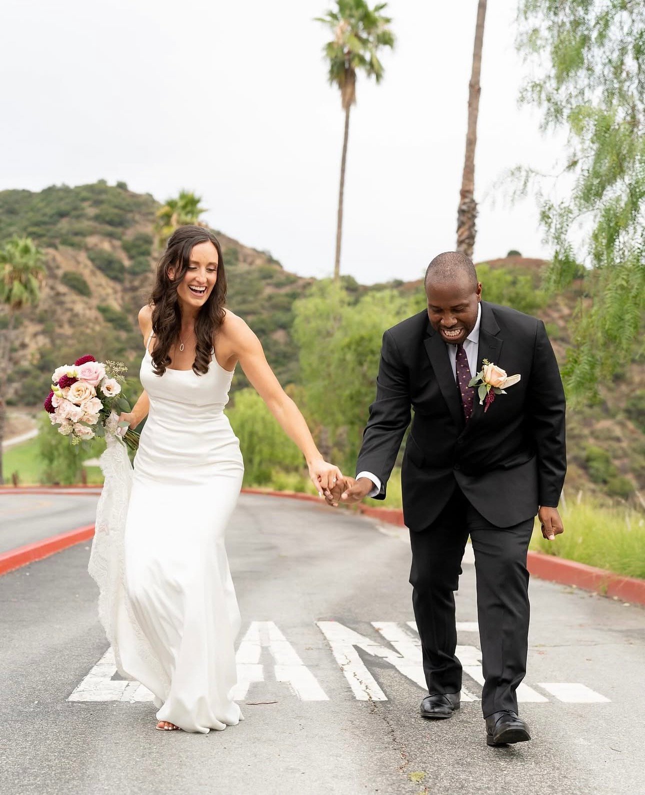 Bride and groom laughing as they walk hand in hand
